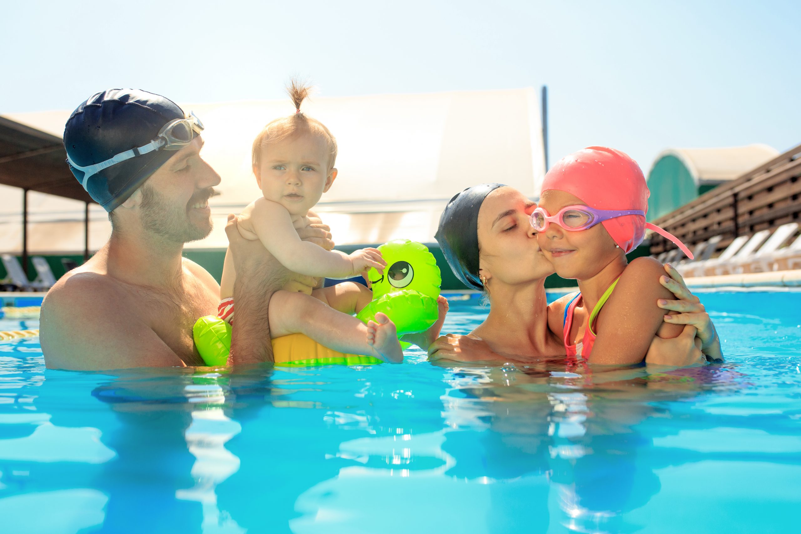 Happy family having fun by the swimming pool. Pool, leisure, swimming, summer, recreation, healthy lifstyle concept